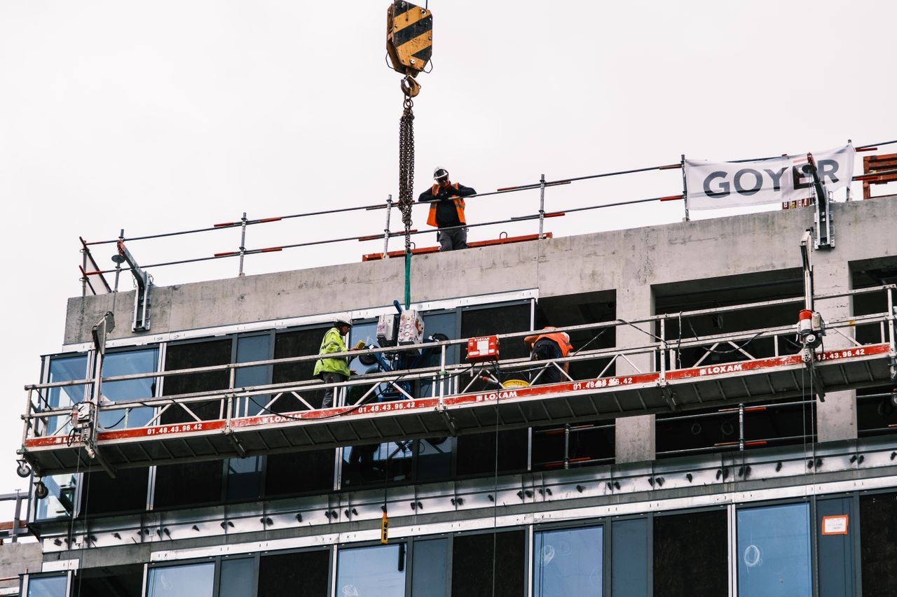 The Art of Drawing Readers In: Your attractive post title goes here Professional workers at a construction site managing equipment on a high-rise building.