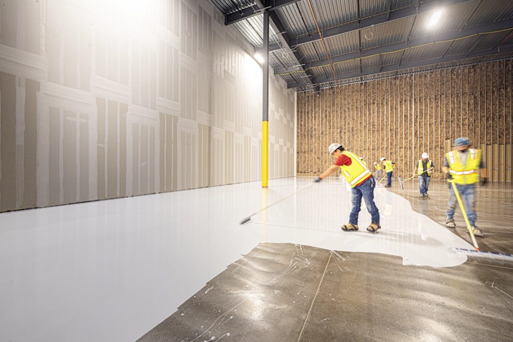 workers-painting-a-large-industrial-floor-white-4ycahdefgfk Professional industrial concrete flooring installation in a Dallas, Texas technology facility. This high-performance, seamless surface is engineered for the rigorous demands of Energy-to-Compute (E2C) and data center infrastructure. Installed by Craftsman Concrete Floors. View technical specs: craftsmanconcretefloors.com/esd-flooring/